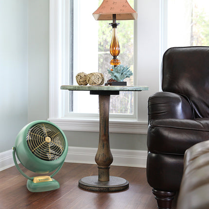 Vintage-style fan next to a table with decorative items in a living room.