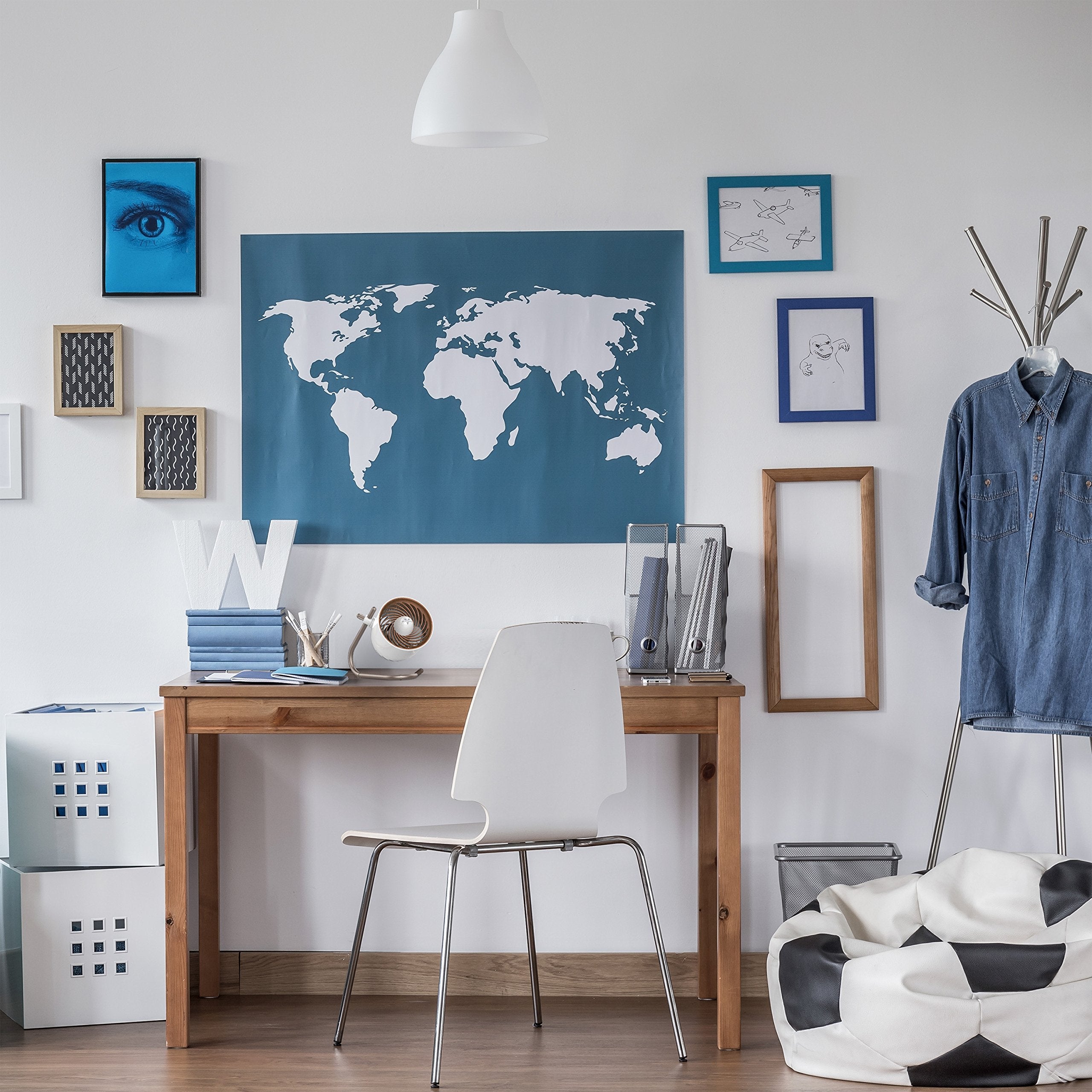 Home office with a world map on the wall, desk, chair, white Vornado desk fan, and bean bag chair.