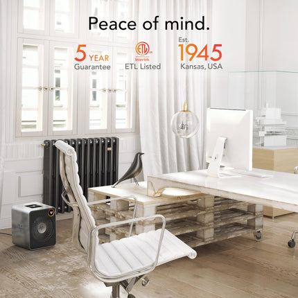 Modern office space with a desk, chair, and space heater, featuring text about product guarantees and establishment year.