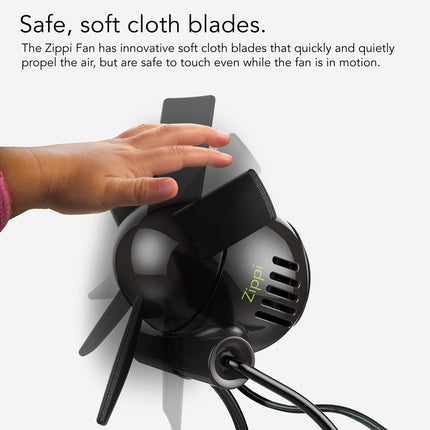 Zippi fan with soft cloth blades and a hand touching it, on a white background.