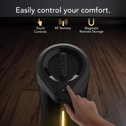 Hand pressing a button on a black fan with text about control methods on a wooden floor.