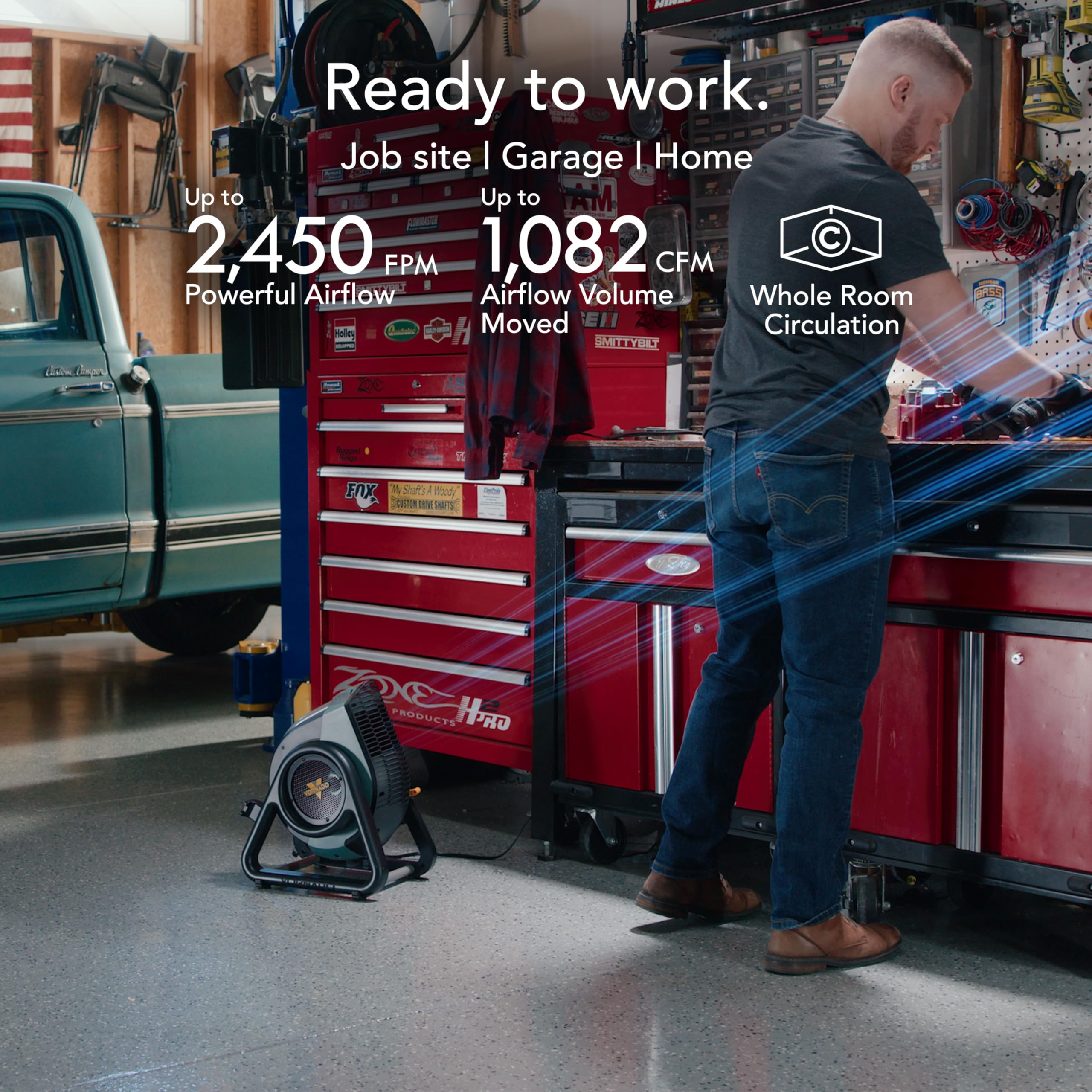 Person in a garage with a powerful air mover, showcasing airflow capabilities.