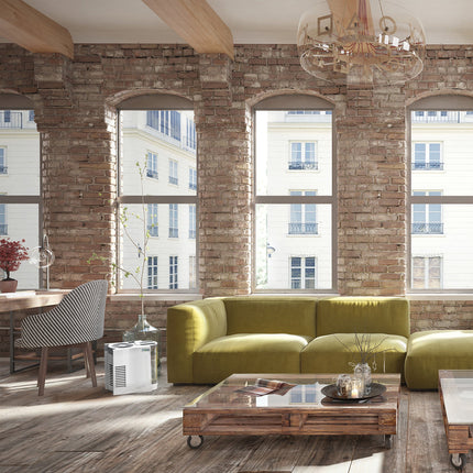 Modern living room with green sofa, wooden coffee table, and brick wall.