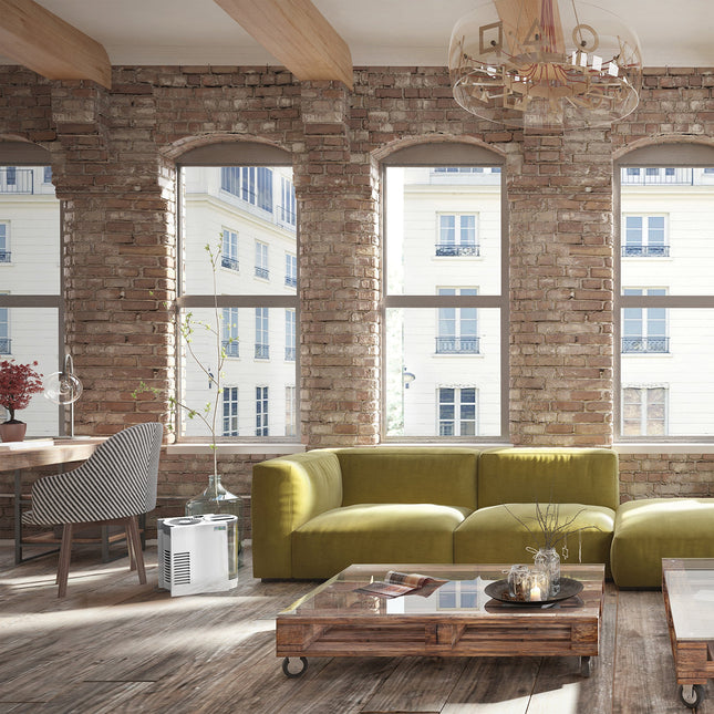 Modern living room with green sofa, wooden coffee table, and brick wall.
