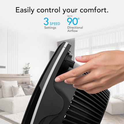 Hand adjusting a black air conditioner unit with text about control settings in a living room.