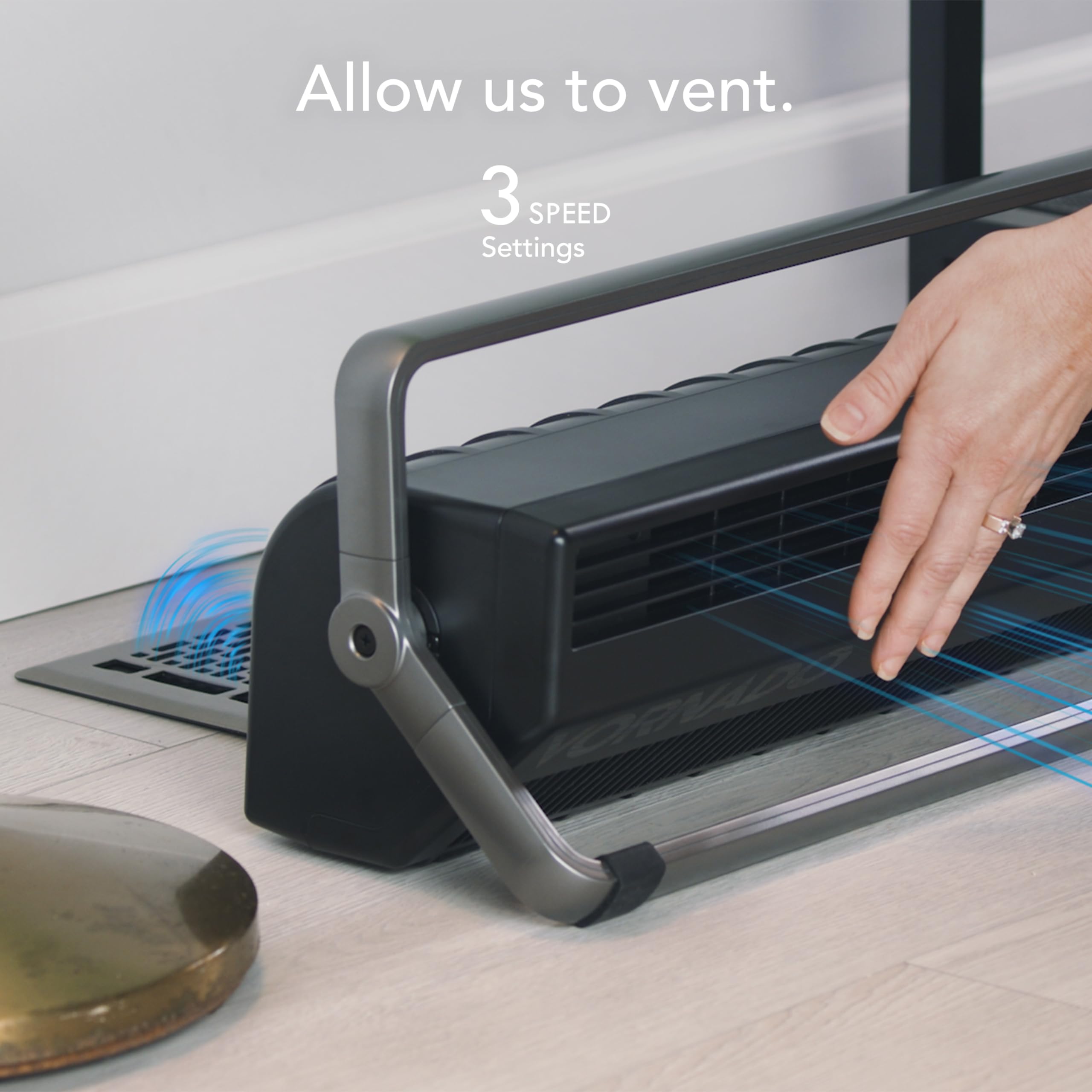 Ventilation system with a hand adjusting it, placed on a surface with a laptop in the background.