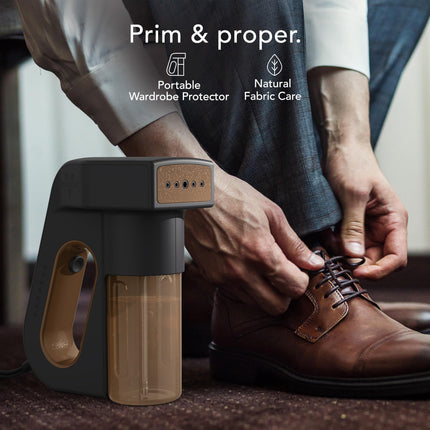 Person cleaning a brown shoe with a portable device, featuring 'Prim & Proper' branding.
