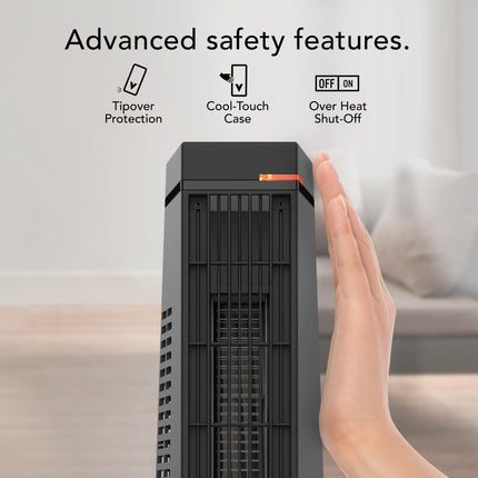 Hand pressing a button on a space heater with safety feature icons above.