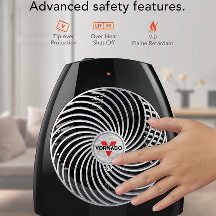 Black electric heater with Vornado logo and safety features text on a blurred indoor background