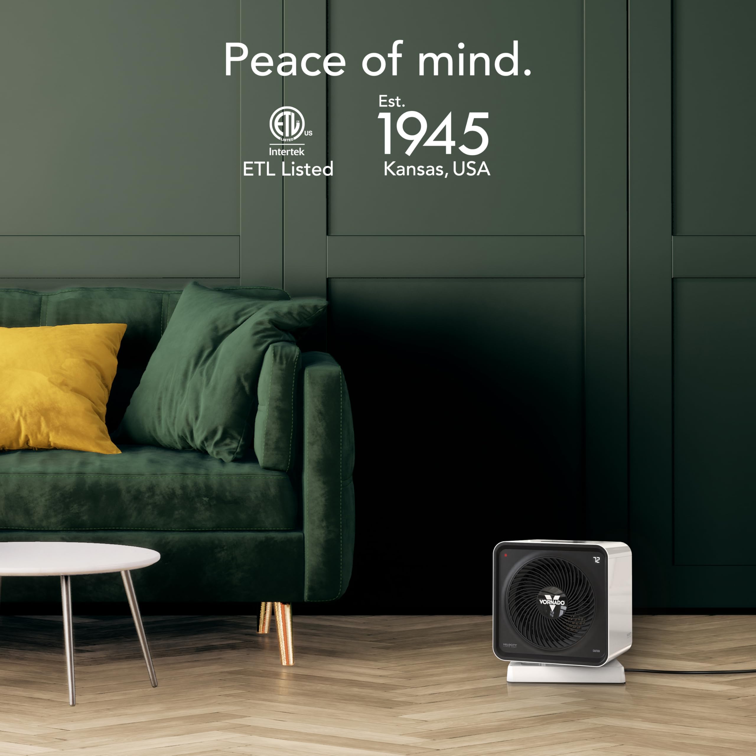 Small space heater on a wooden floor with a green couch and wall in the background, featuring ETL Listed and Interlock branding.