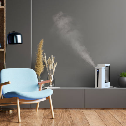 Modern living room with a blue chair, gray cabinet, and a humidifier emitting mist.