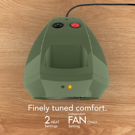 Green space heater on a wooden surface with text about comfort settings.