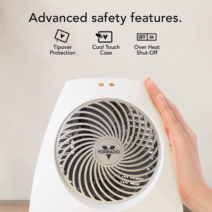 Vornado heater with hand touching it, highlighting safety features on a light background