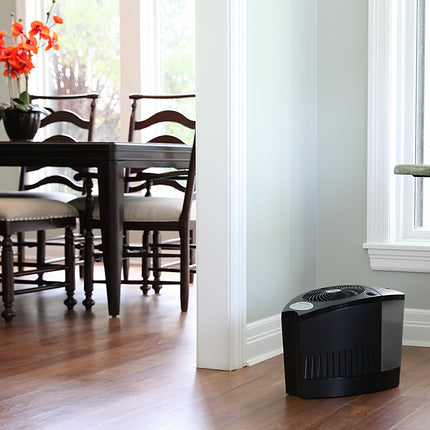 Humidifier on a wooden floor with a dining area in the background