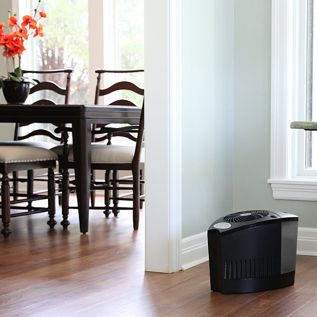 Humidifier on a wooden floor with a dining area in the background