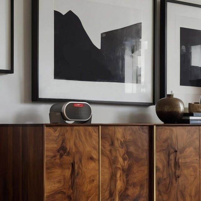 Wooden cabinet with a heater and framed abstract art on a white wall