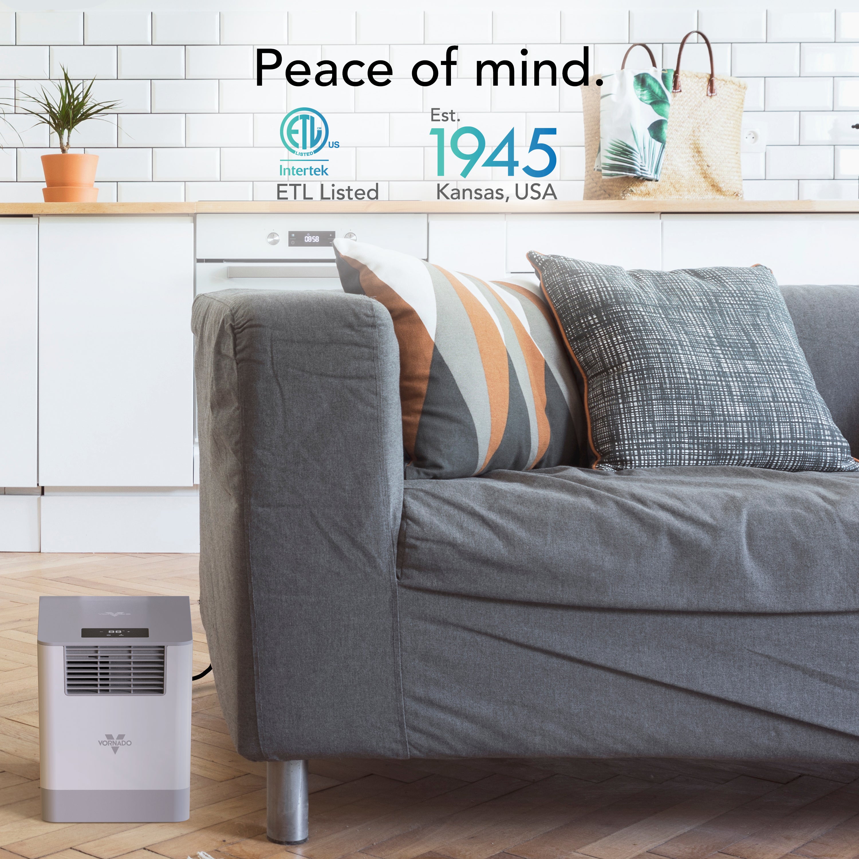 Gray sofa with decorative pillows in a living room setting featuring a Vornado humidifier, featuring ETL Listed logo and text.