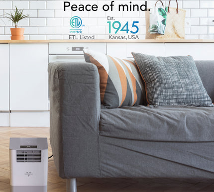 Gray sofa with decorative pillows in a living room setting featuring a Vornado humidifier, featuring ETL Listed logo and text.