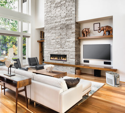 Modern living room with white sofa, wooden coffee table, and stone fireplace.