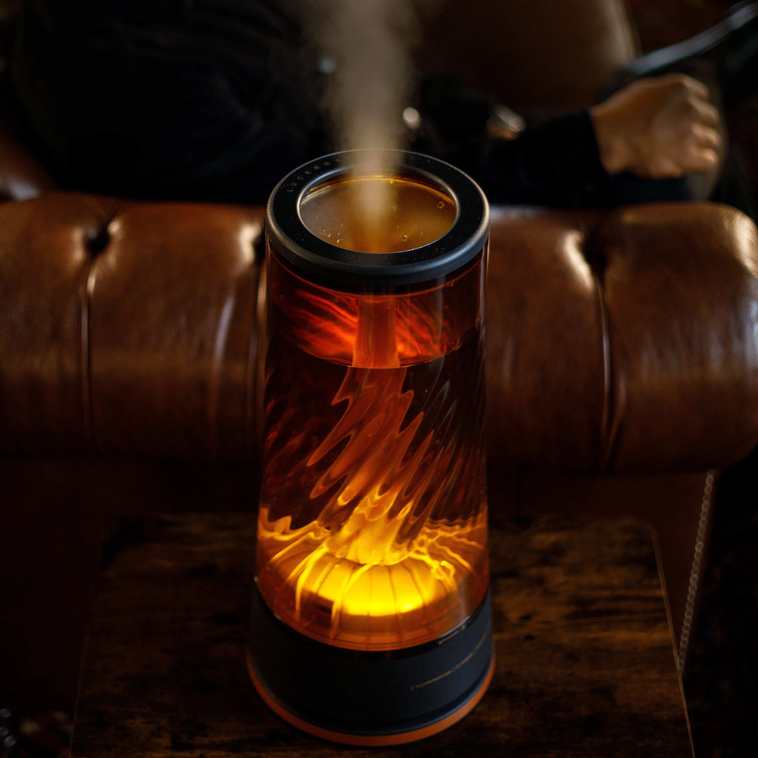 Decorative humidifier emitting steam on a brown leather couch