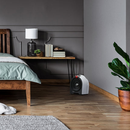 Modern bedroom with wooden bed, nightstand, and heater on wooden floor.