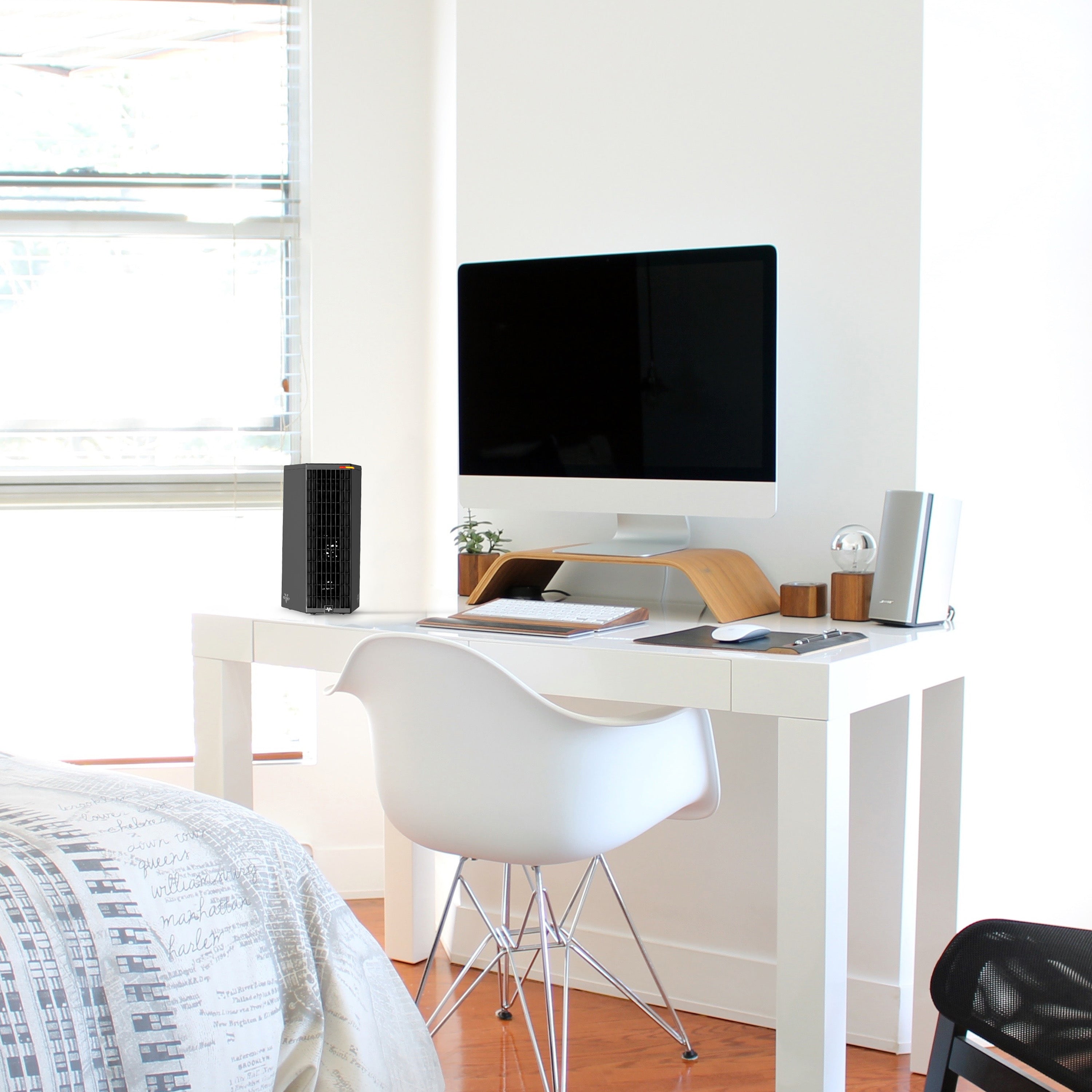 Modern bedroom with a white desk, desk heater, and computer setup.
