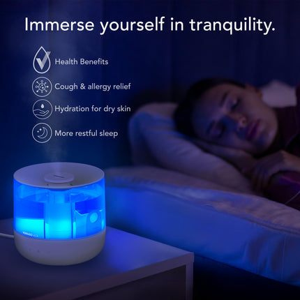 Person lying down with an ultrasonic humidifier on a nightstand, emitting blue light.