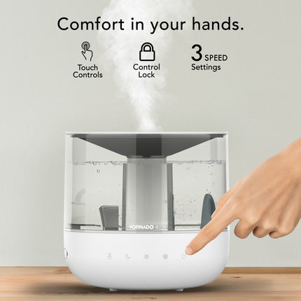 White humidifier with touch controls and steam release, on a wooden surface.