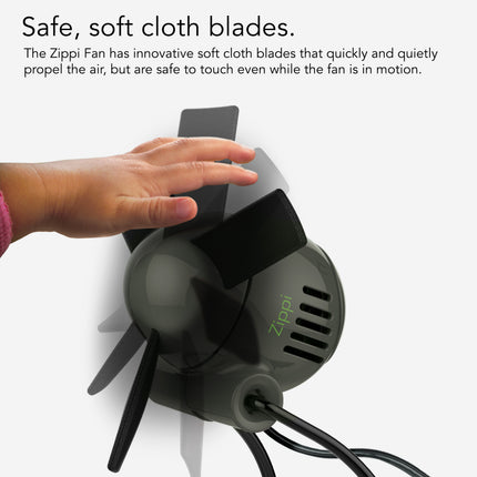 Zippi fan with soft cloth blades and a hand touching it, on a white background.