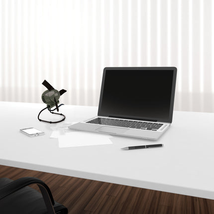 Laptop on a white desk with a smartphone and desk fan, against a white curtain background
