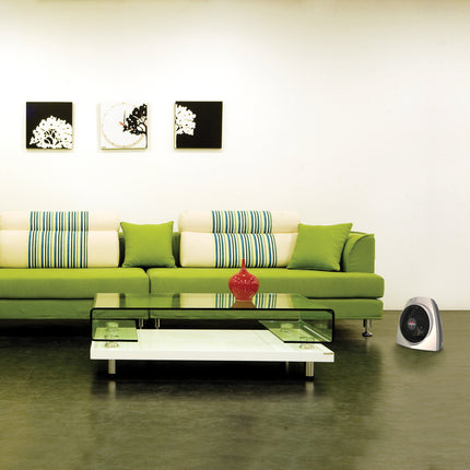 Modern living room with a green sofa, glass coffee table, and decorative elements.
