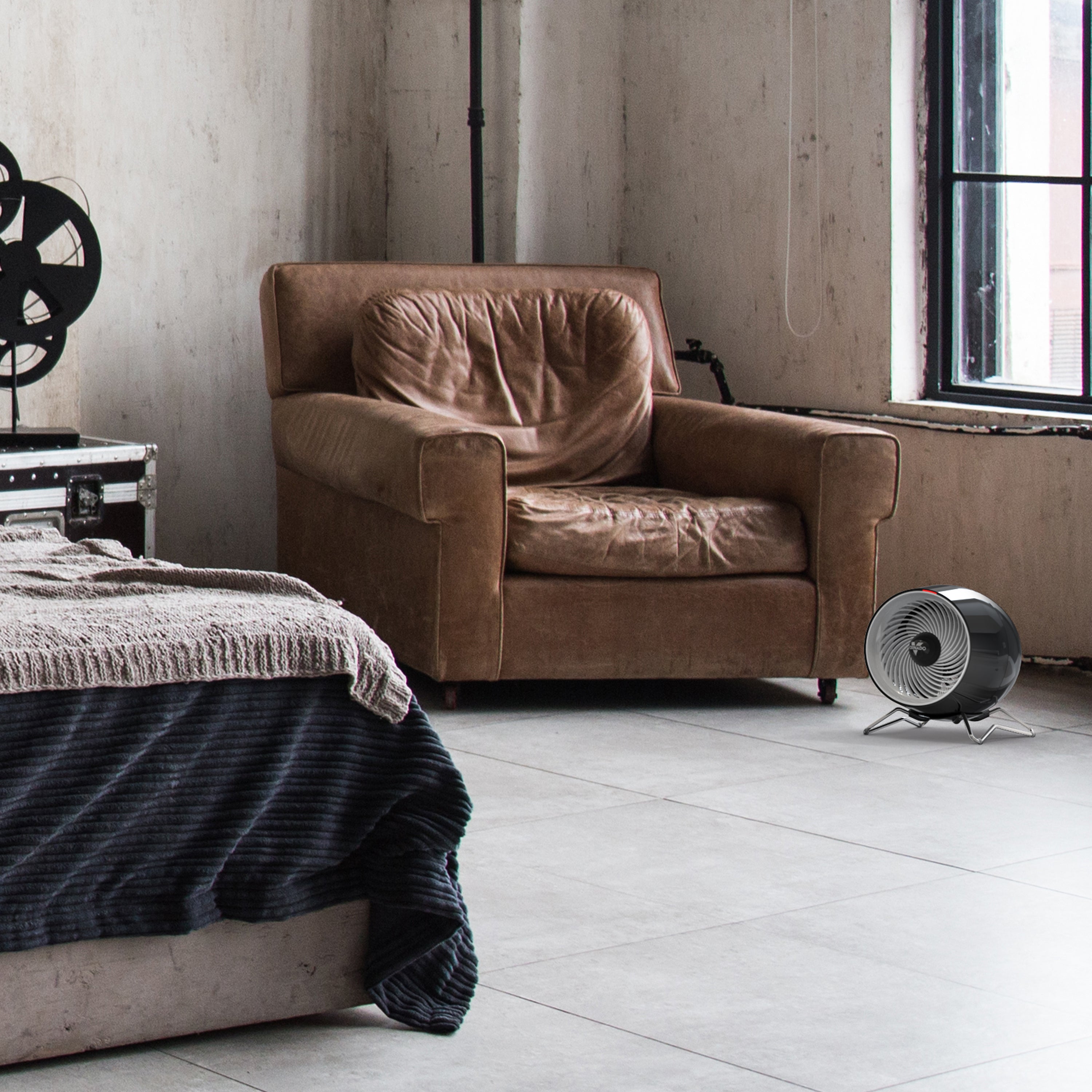 Brown armchair in a room with a window and a floor fan.