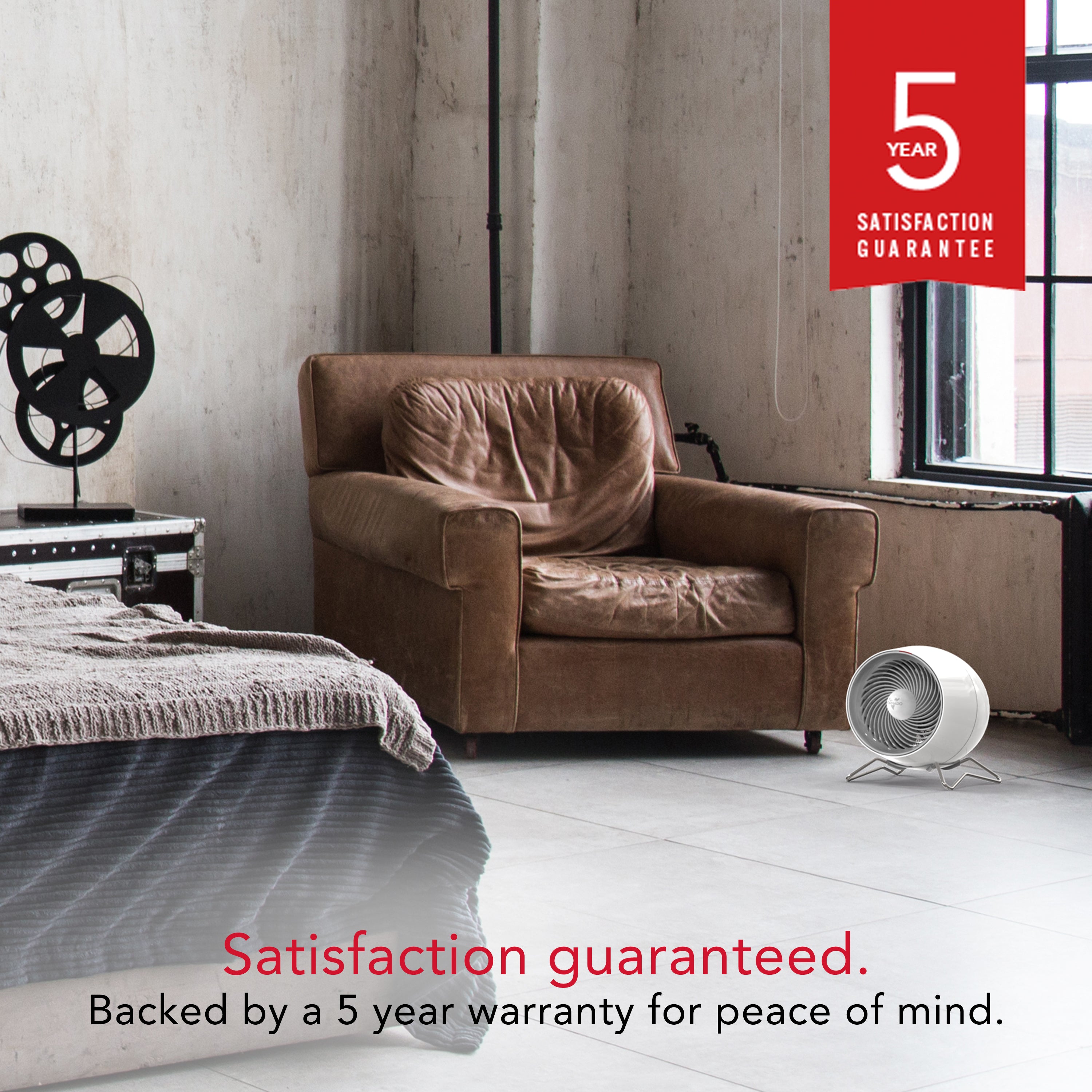 Brown armchair in a room behind a white Vornado heater with a 5-year satisfaction guarantee badge.