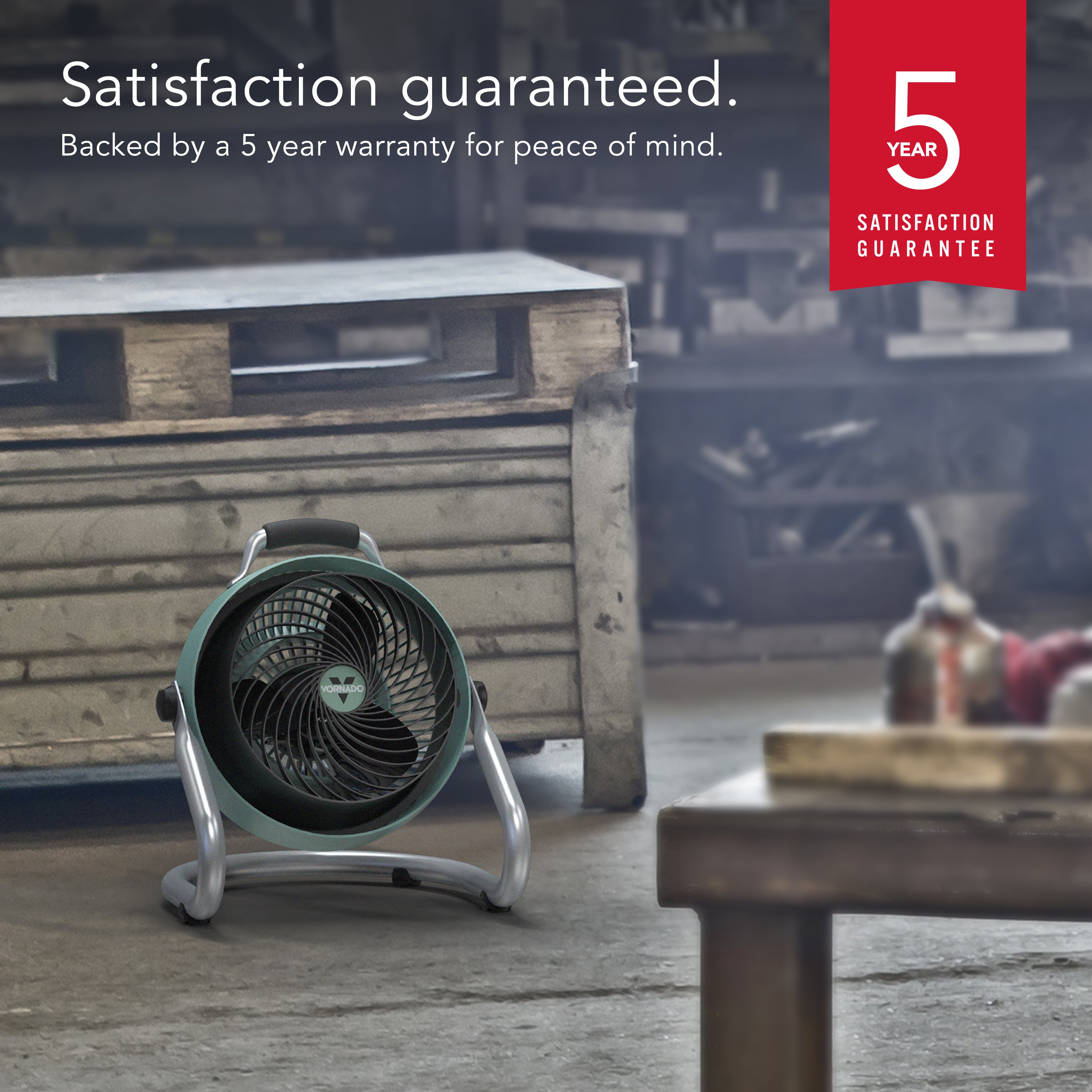 Small fan on a wooden floor with a 5-year satisfaction guarantee badge in the corner.