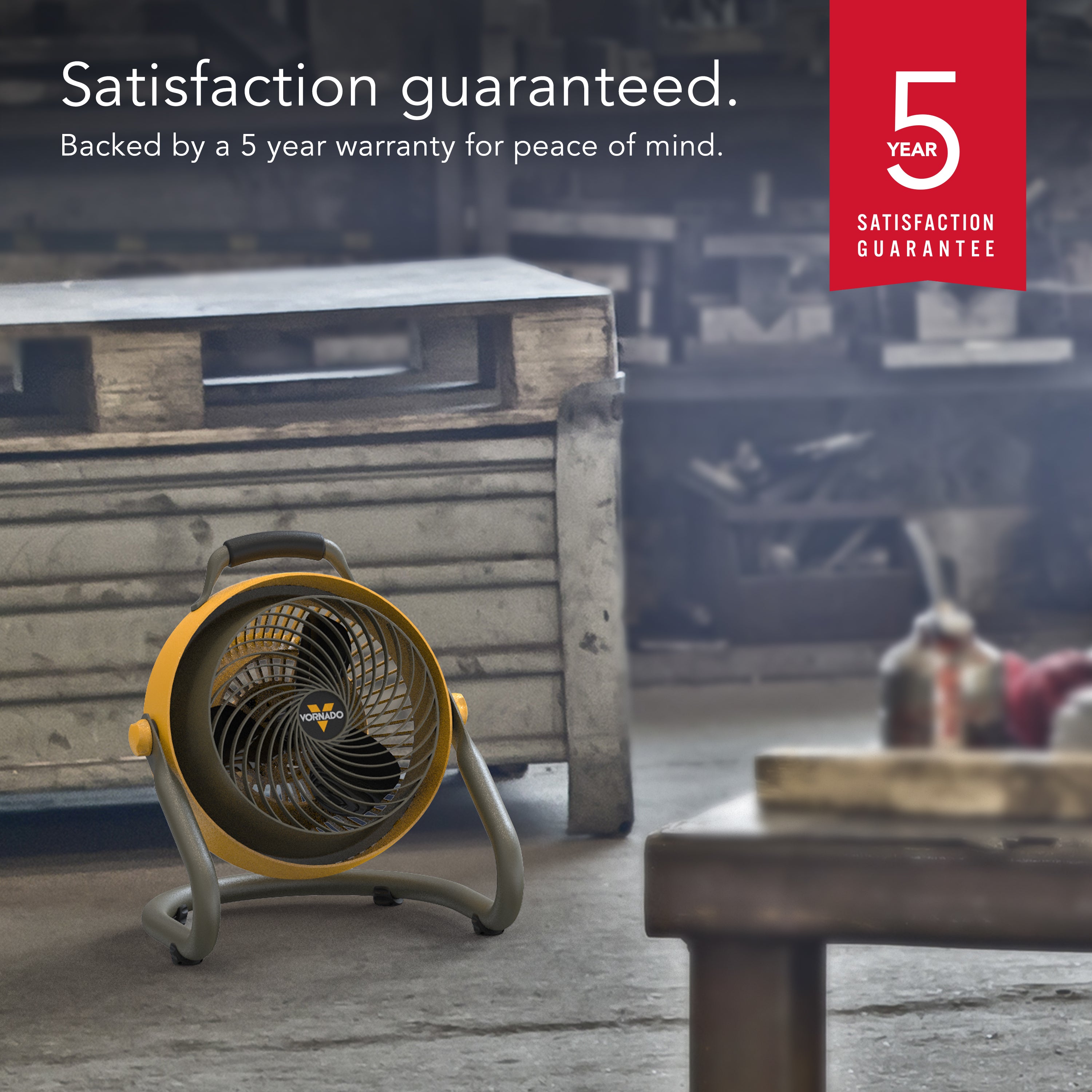 Portable fan on a wooden pallet with a 5-year satisfaction guarantee badge in the corner.