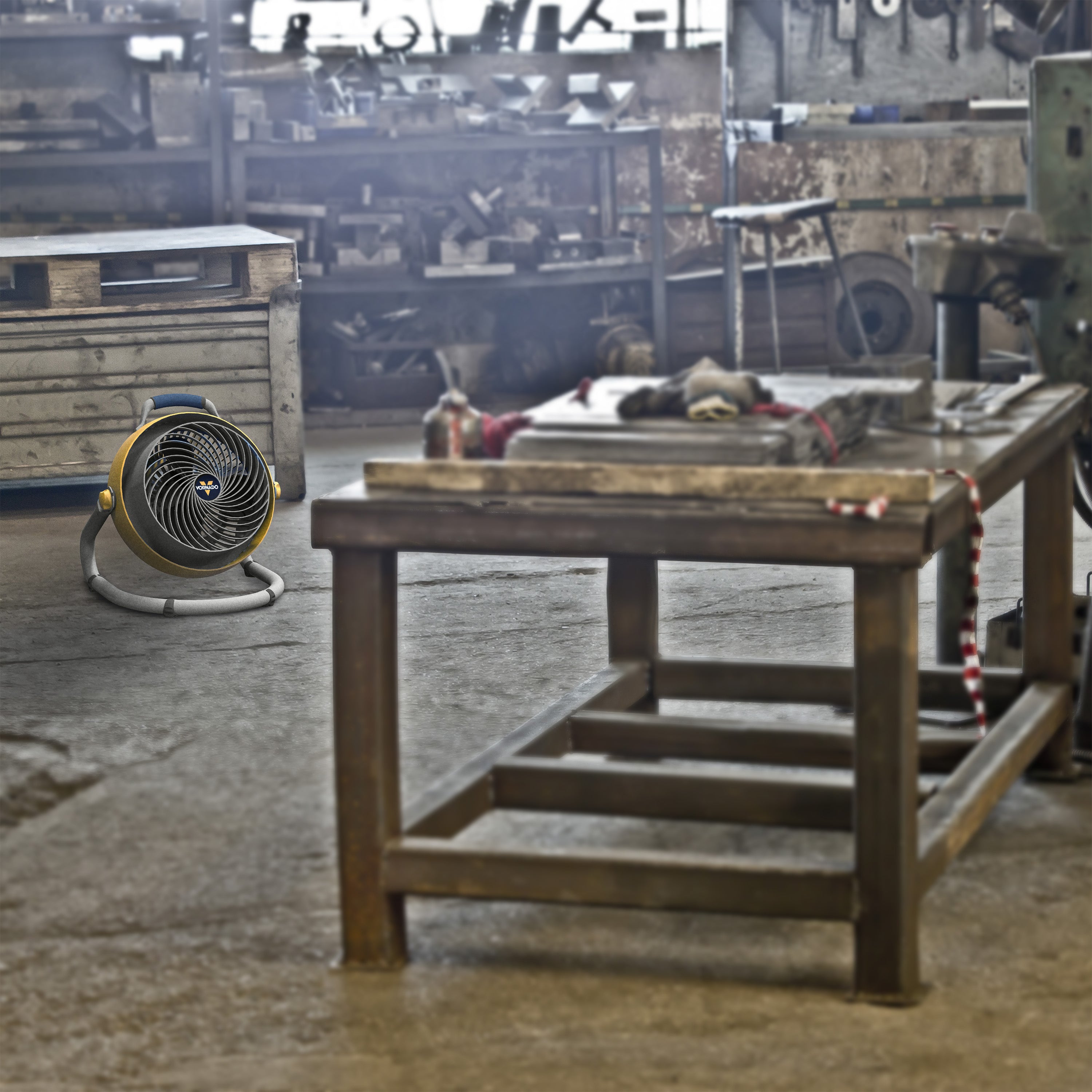 Workshop with a wooden table and fan in the foreground