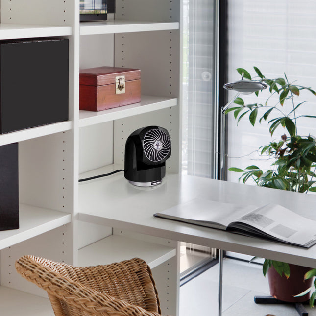 Modern office setup with a desk, chair, and shelves next to a black fan