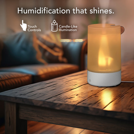 Humidifier with candle-like illumination on a wooden table, surrounded by a cozy living room setting.