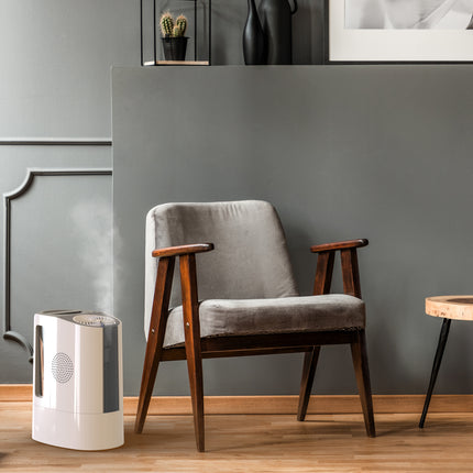 Gray armchair with wooden arms and legs in a room with a gray wall and small table.