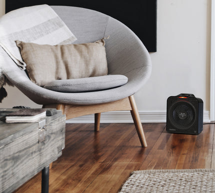 Modern chair with a pillow and space heater on a wooden floor.