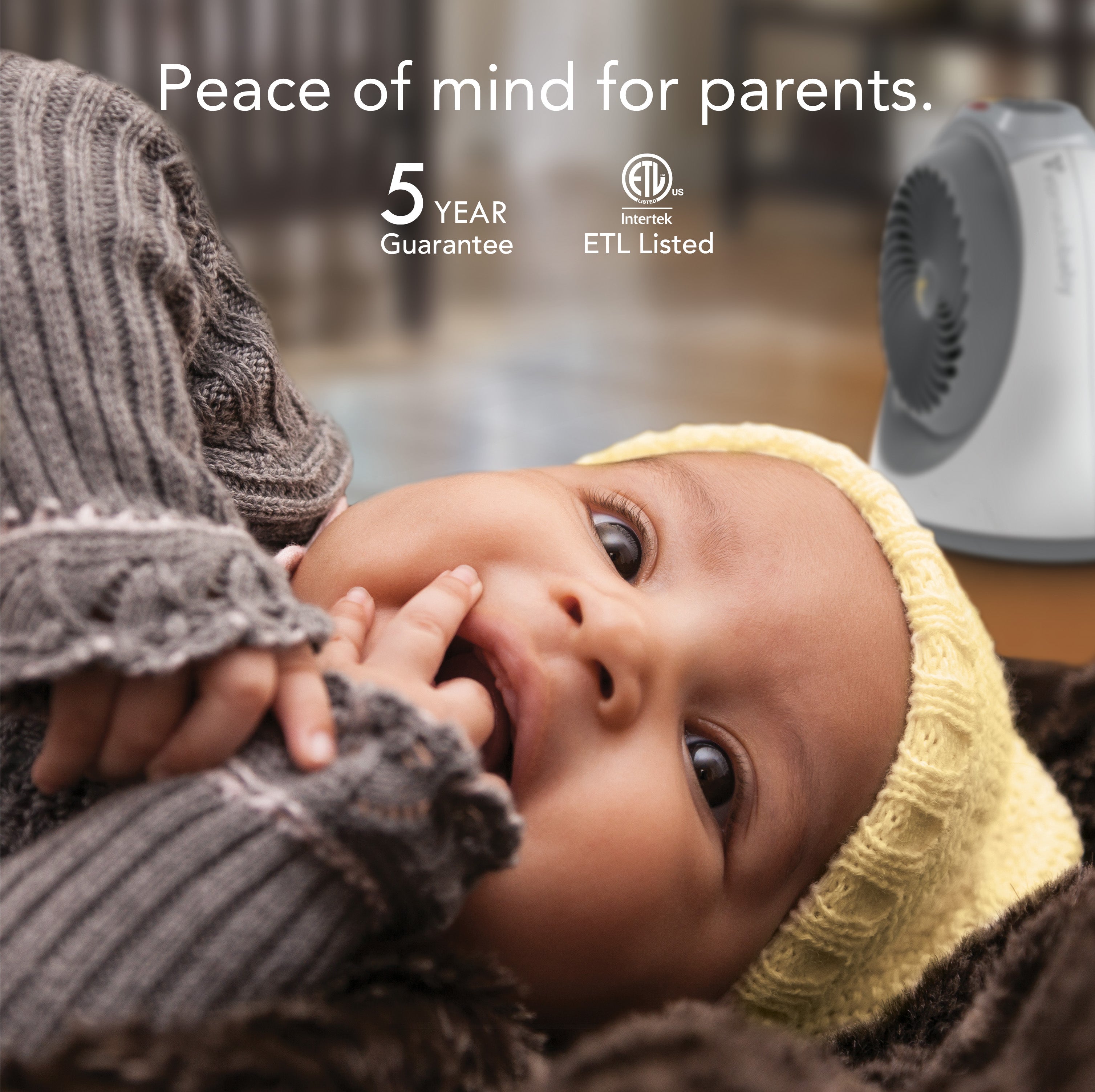 Baby being held by a person with a product in the background, featuring text about a 5-year guarantee and ETL listing.