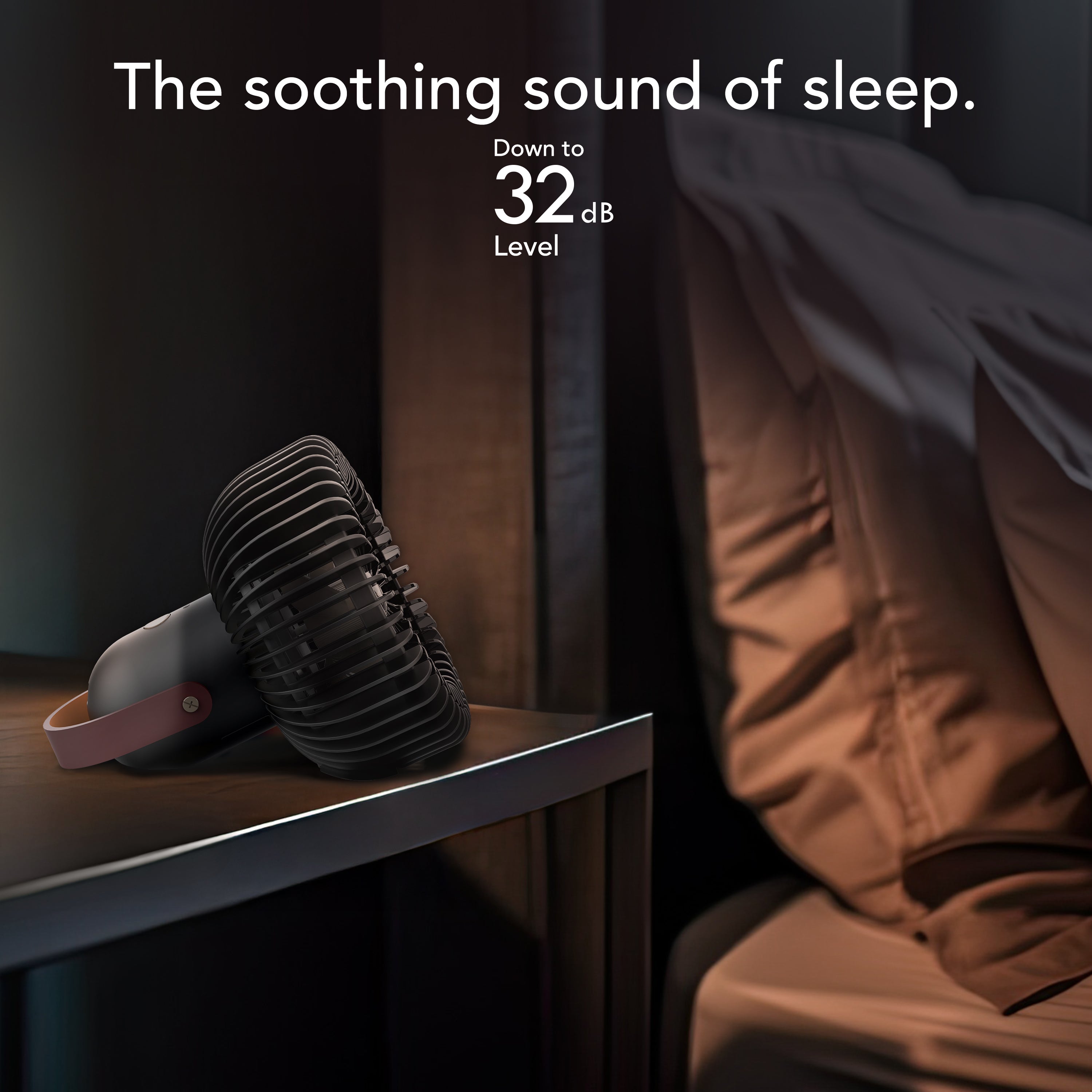 Black personal fan on a nightstand next to a bed with text about sound level.