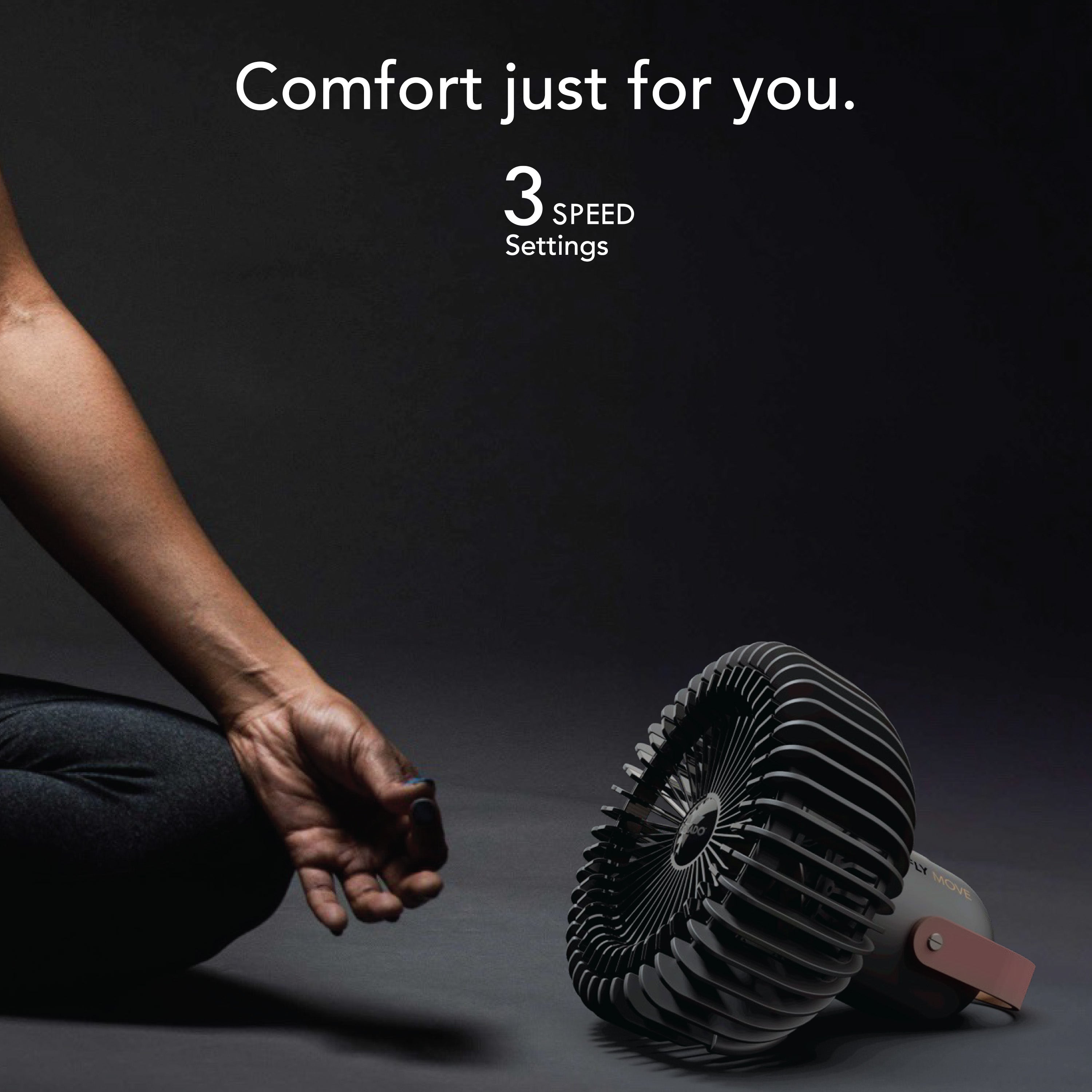Person meditating with a fan on a dark background, emphasizing comfort and three speed settings.