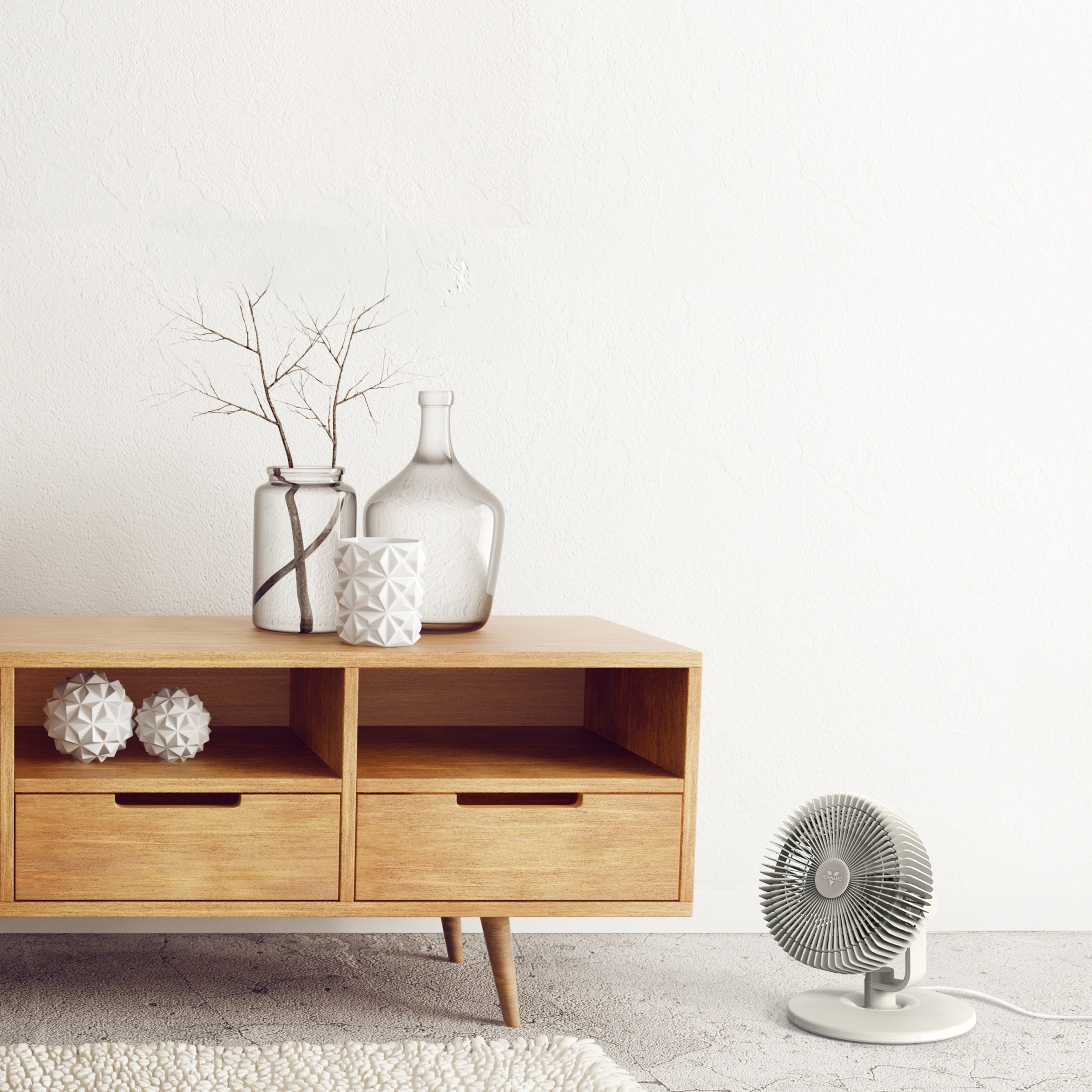 Wooden sideboard with decorative items and a small fan on a light-colored floor.