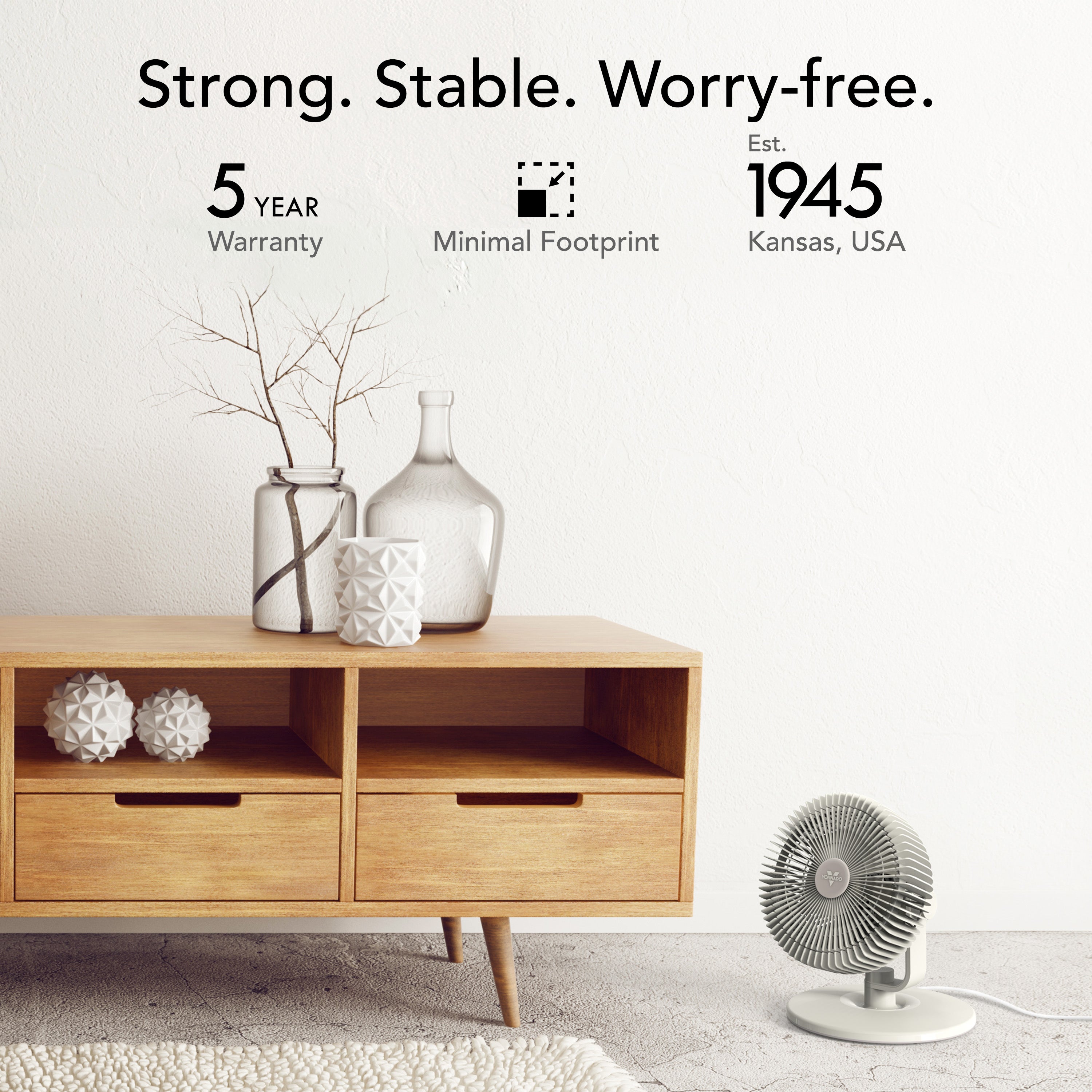 Wooden cabinet with decorative items and a small fan on a light gray floor.