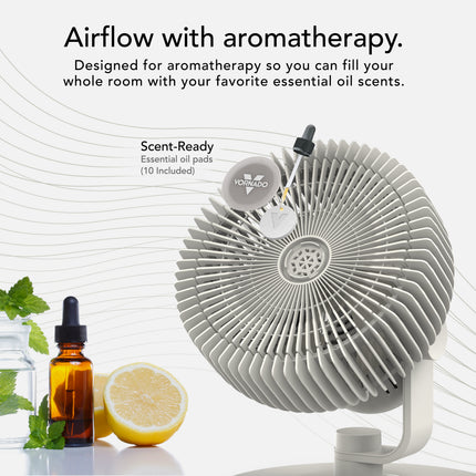 White fan with essential oil bottles and lemon on a white background, promoting aromatherapy.