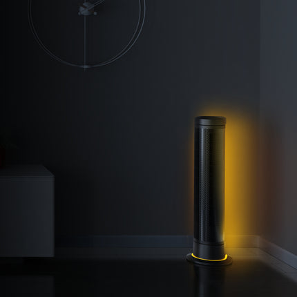 Black tower fan emitting a yellow light in a dark room