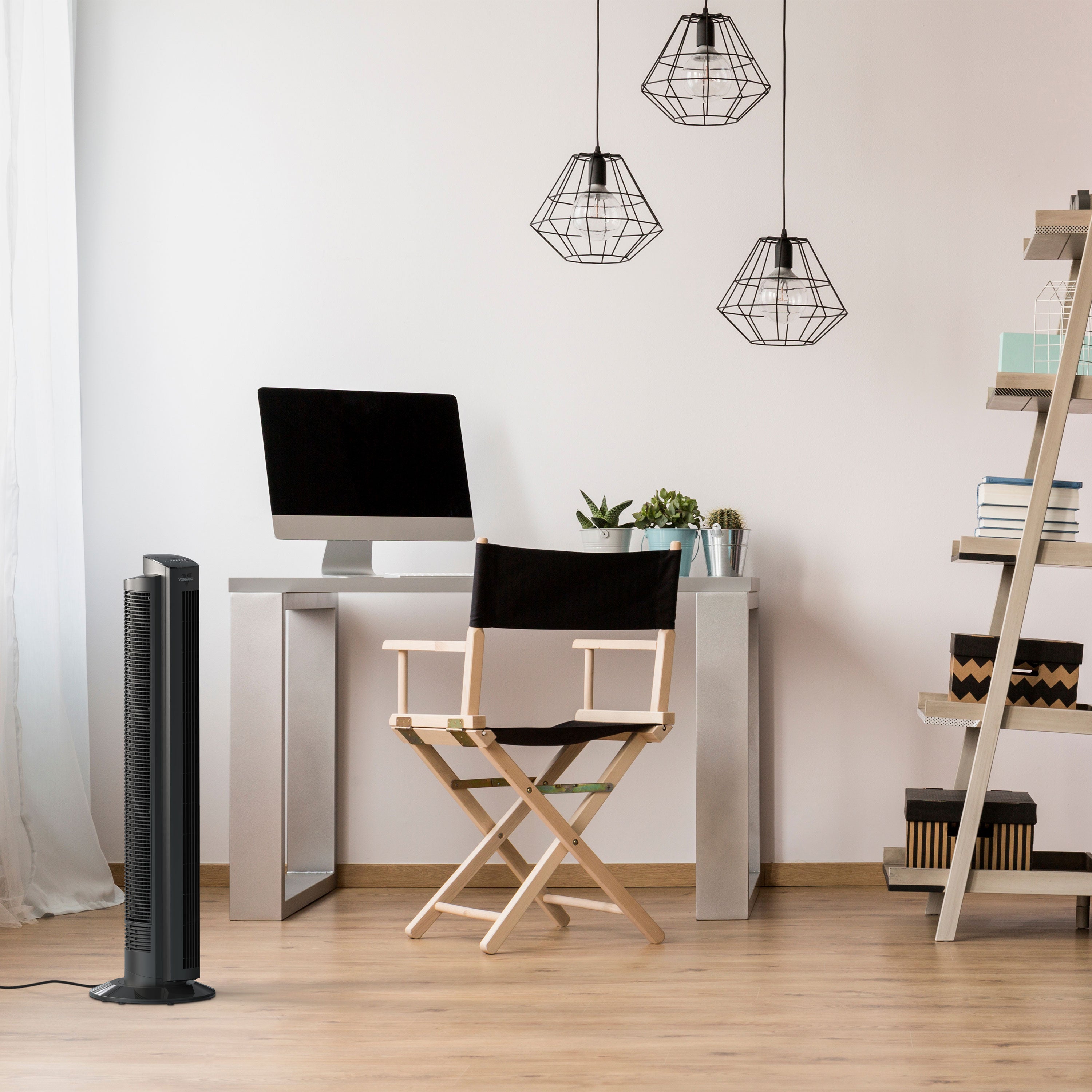Modern home office with a desk, chair, computer monitor, and tower fan.