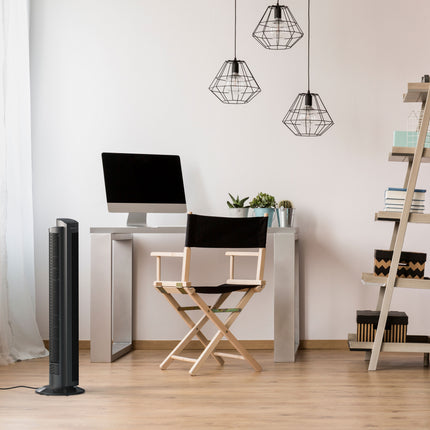 Modern home office with a desk, chair, computer monitor, and tower fan.