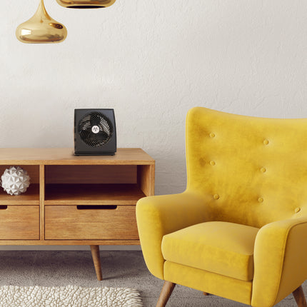 Yellow armchair in a living room with a wooden cabinet and decorative items.
